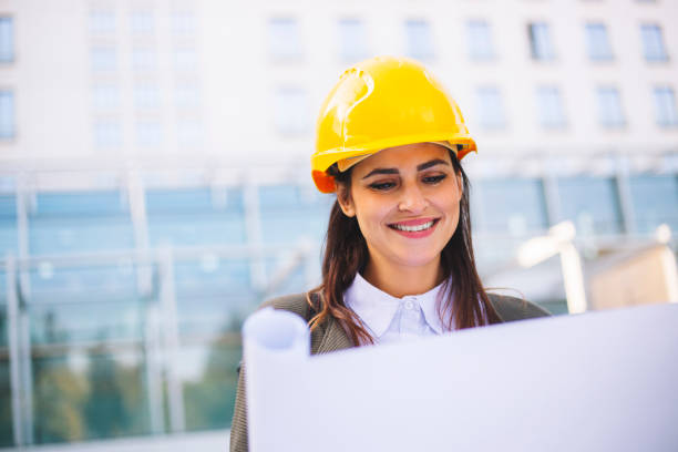 istock Young female architect reviewing building plan 1063664680