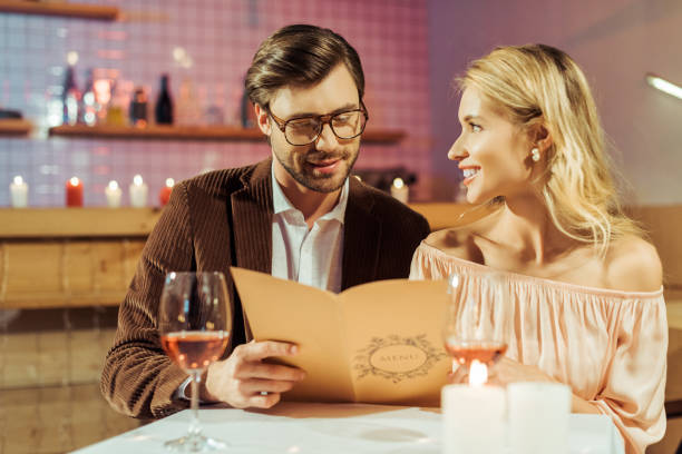 istock happy young couple looking at menu during romantic dinner in restaurant 1063665884