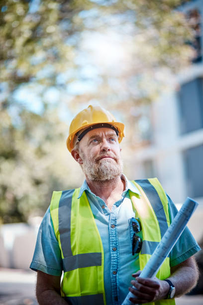 istock Mature building professional with blueprints looks up at building 1063665974