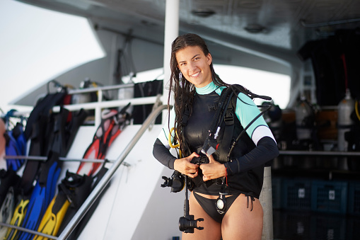Female scuba diver putting her diving equipment on.\n\nNOTE TO INSPECTOR: Please revise the Model Release attached.