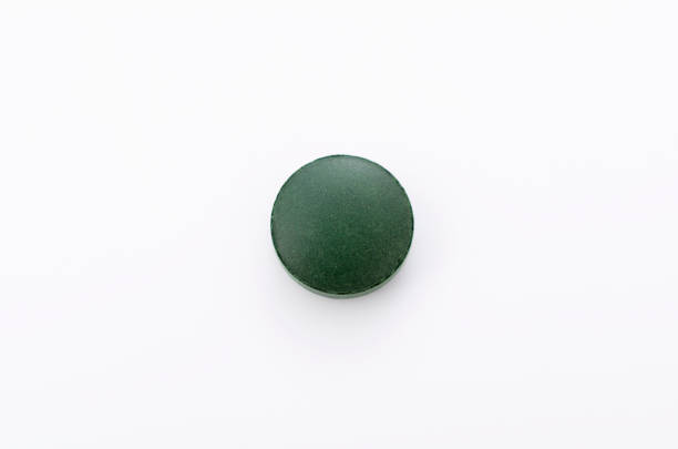 istock green pills,Spirulina tablets on white background 1063668802