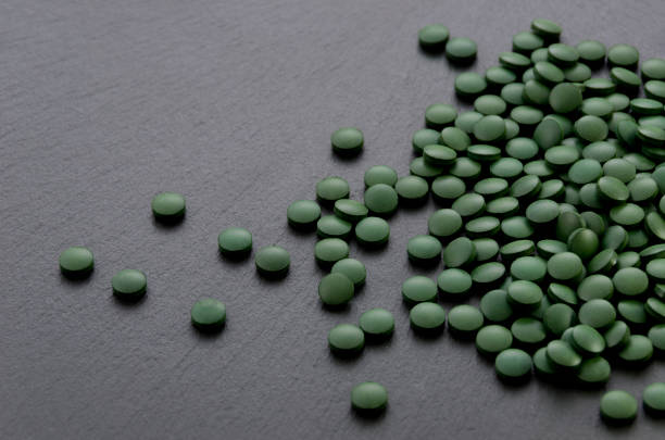 A macro shot captures a single brown vitamin pill resting on a neutral surface. The close-up perspective highlights the pill's texture and form, emphasizing themes of health, nutrition, and medicine. Perfect for illustrating concepts related to dietary supplements, pharmaceuticals, and wellness.