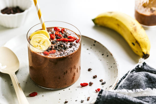 banana,coconut water, chia seed and cacao smoothie with goji and cacao nib topping - food vegan food gourmet vegetarian food imagens e fotografias de stock
