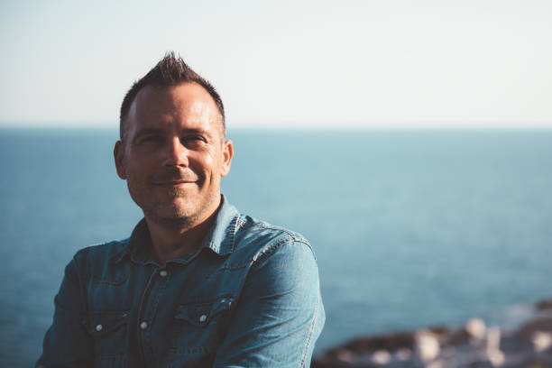 istock Men wearing denim shirt standing by the sea 1063671438