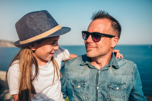 istock Daughter embracing and talking with father by the sea 1063674062