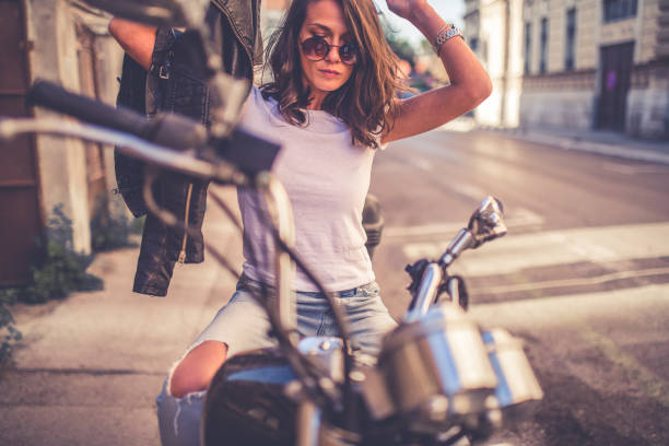 istock Young pretty fashioned girl sitting on her motorcycle 1063674608