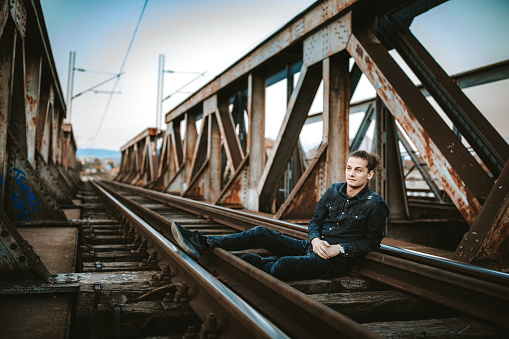 Attractive young man on on railway bridge