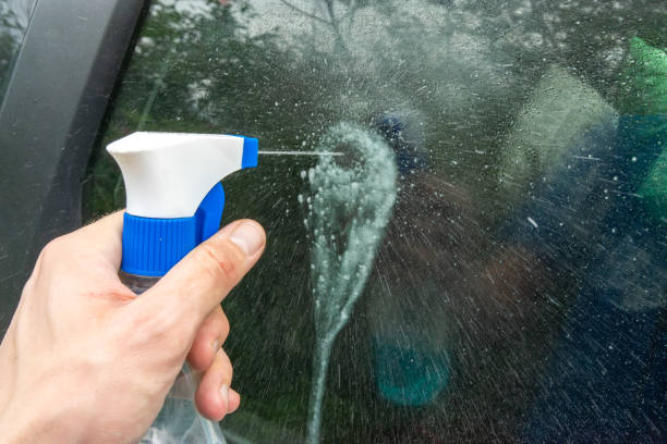istock A hand holding a plastic spray bottle splashes onto a car's glass. 1063676400
