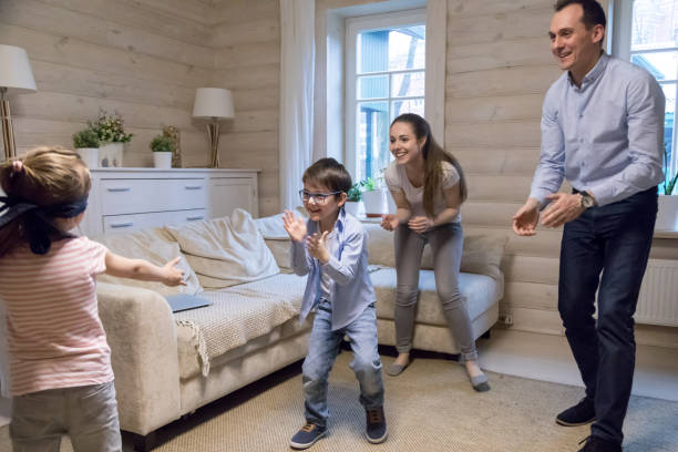 istock Small blindfolded girl playing hide and seek with family 1063676522