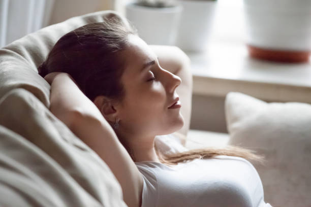 istock Calm woman relaxing on sofa hands over head 1063676706