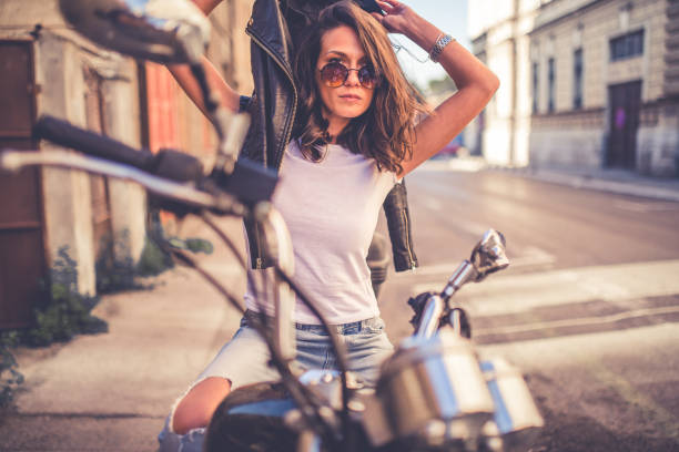istock Young pretty fashioned girl sitting on her motorcycle 1063676922