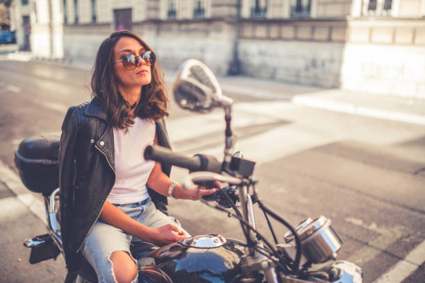 istock Young pretty fashioned girl sitting on her motorcycle 1063677310