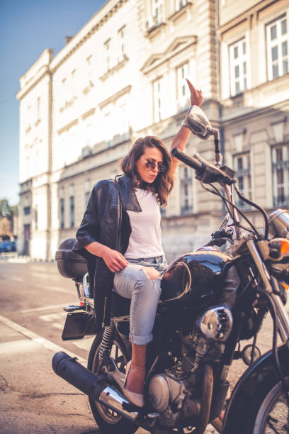 istock Young pretty fashioned girl sitting on her motorcycle 1063677622
