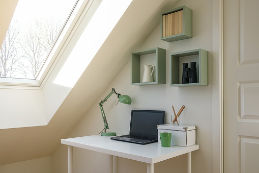 Interior del espacio de trabajo moderno. Ordenador portátil, lámpara retra y accesorios para la oficina en un escritorio blanco. photo