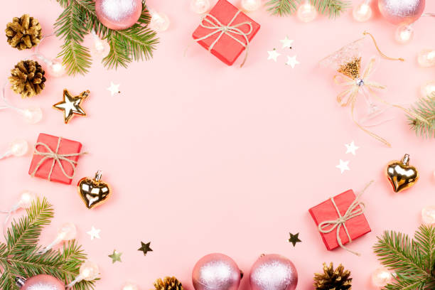 istock Christmas background with fir branches, lights, red giftboxes, pink decorations on pink 1063682448