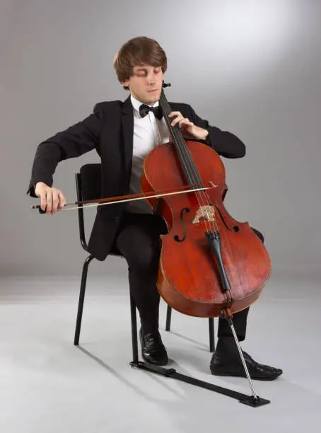 Portrait of the cellist on a light background.
