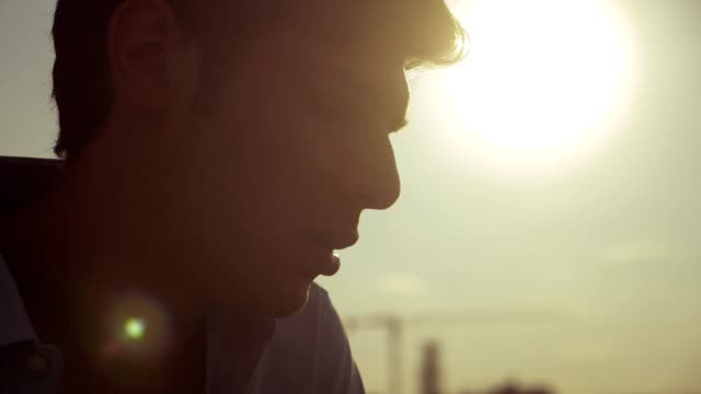 lonely pensive man smoking electronic cigarette at sunset-slow motion