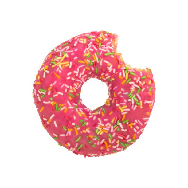 istock Bitten pink donut with colorful sprinkles isolated on white background. Top view. 1063691254