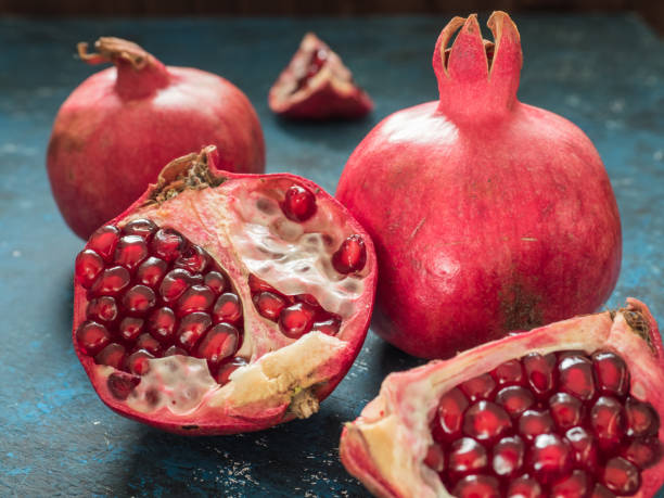 istock Fresh ripe red pomegranate fruit on a dark blue rustic background. Healthy food, closeup, flat lay, top view 1063701588