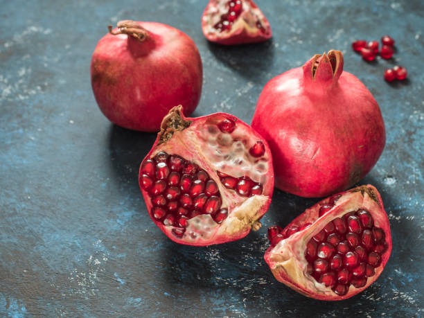 istock Fresh ripe red pomegranate fruit on a dark blue rustic background. Healthy food, closeup, flat lay, top view 1063701590