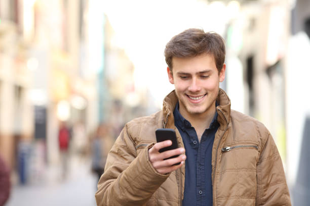istock Front view of happy man texing on phone in winter 1063703696