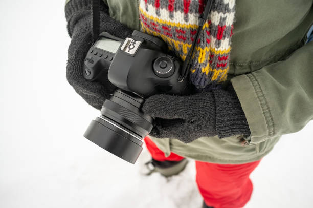 istock Hands in warm knitted gloves hold a professional camera, in the 1063704254