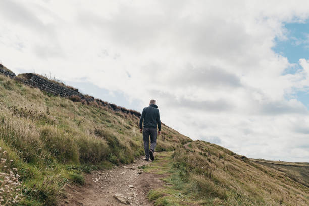 istock Man walking the coast path at Pentire, Newquay, Cornwall on a Autumn day. 1063704490