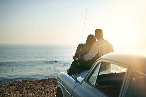 Shot of a young couple making a stop at the beach while out on a roadtrip