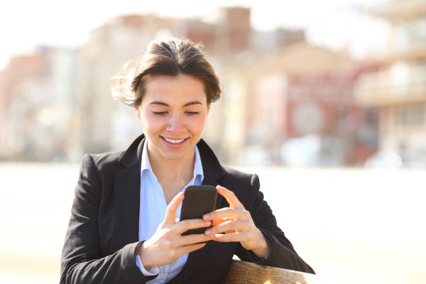 istock Happy busineswoman texting on phone in a park 1063706166