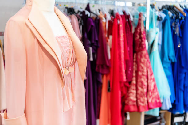 closeup of colorful summer dress on hangers in a woman fashion store showroom