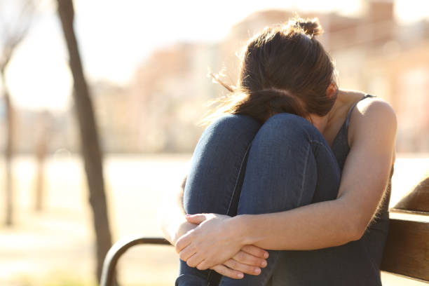 istock Sad woman complaining on a bench in a park 1063709004
