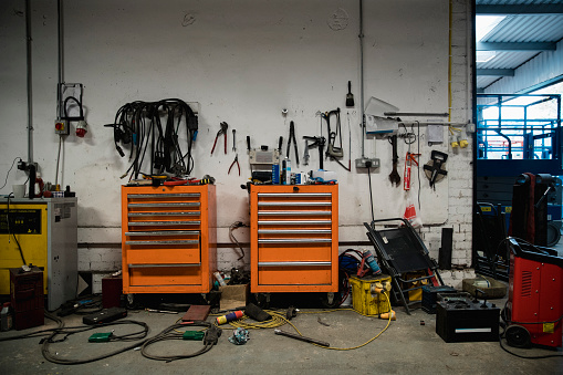 A wide-view shot of a tool bench in a messy warehouse.