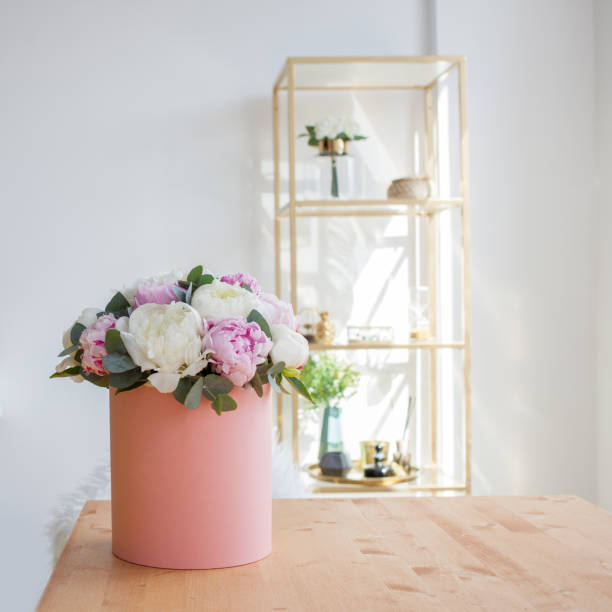istock Flower delivery to the office. Working space, table with notebooks and magazines. A luxurious bouquet of peonies 1063713154