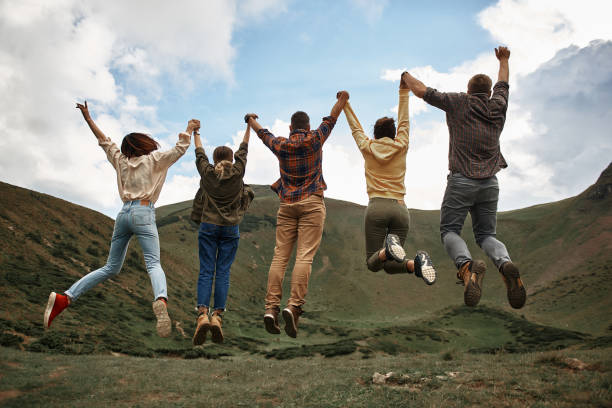 istock Excited friends holding hands and jumping while being in the mountains 1063713986