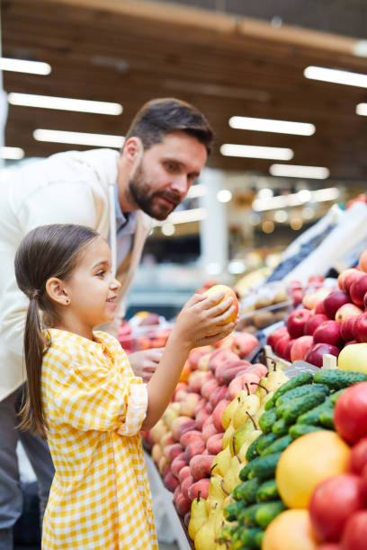 istock Father teaching daughter to pick up fruits 1063716220