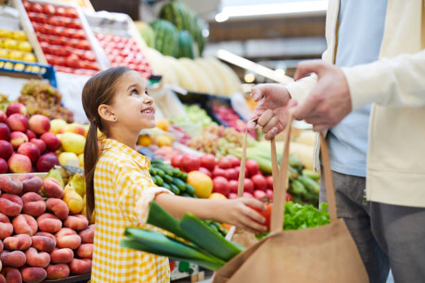 Cute girl helping father with shopping