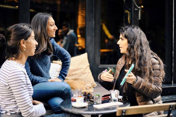 Friends sharing stories with each other at a cafe stock photo