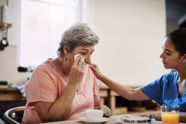 It's just been a very emotional time for me... Cropped shot of an attractive young female caregiver consoling a senior patient in a nursing home wiping tears stock pictures, royalty-free photos & images