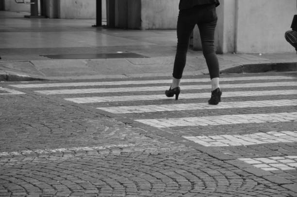 istock Zoom on a Crosswalk in a City (legs and shoes) 1063721652