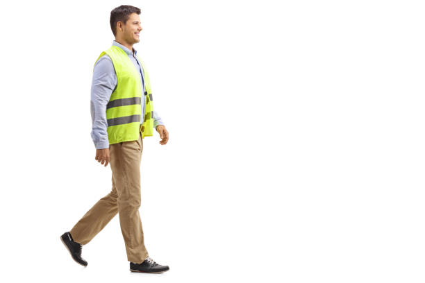 istock Smiling young man wearing safety vest and walking 1063723936