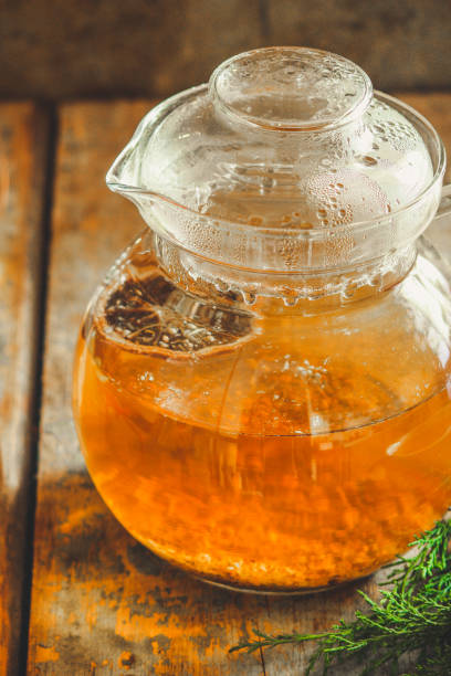 istock tea in a transparent teapot on the table (herbal tea is brewed). top view. 1063724238