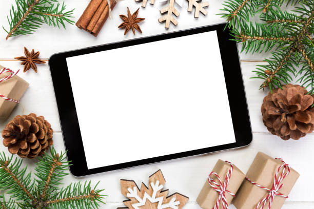 istock Digital tablet mock up with rustic Christmas wooden background decorations for app presentation. top view with copy space 1063725254