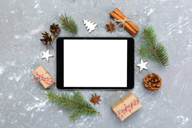 istock Digital tablet mock up with rustic Christmas gray cement background decorations for app presentation. top view with copy space 1063725398