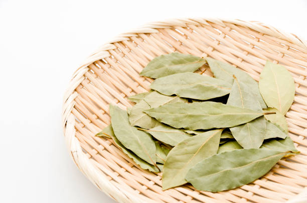 istock Dried bay leaves on bamboo sieve on white background. 1063727020