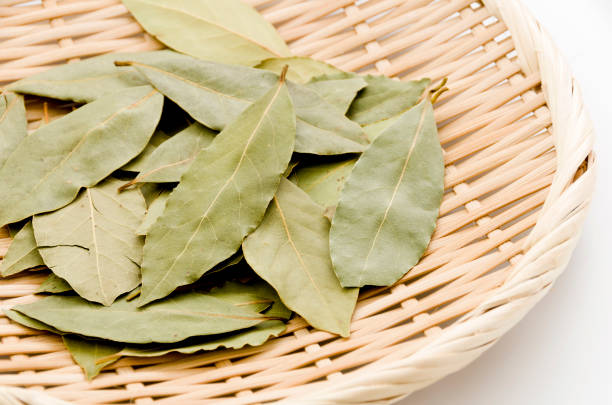 istock Dried bay leaves on bamboo sieve on white background. 1063727128