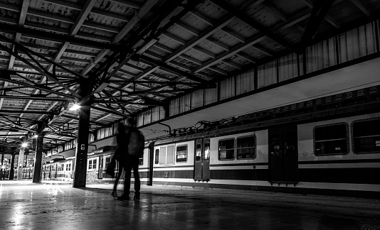Silhouette of happy woman and man embracing on railway platform