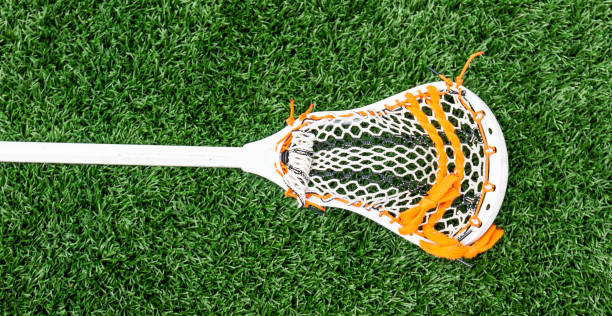 istock Lacrosse stick with orange webbing on the turf 1063730790