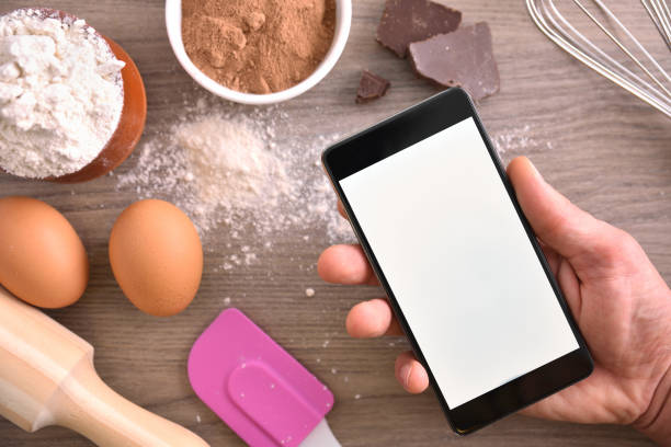 istock Hand with mobile to cook in the kitchen 1063731106