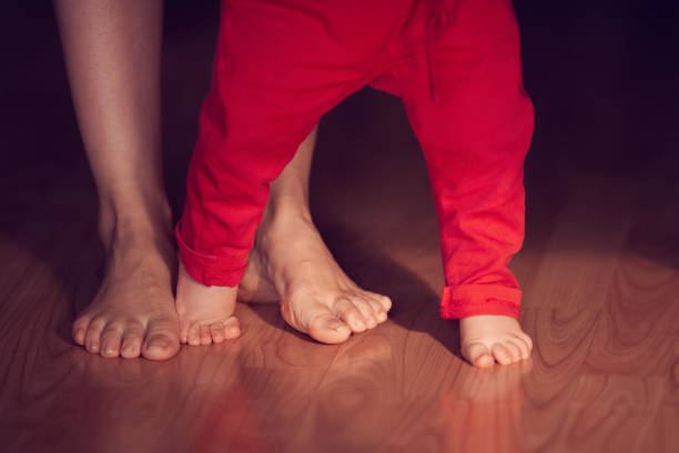 lifestyle shot of mother with her baby girl learning to walk.unrecognizable people.