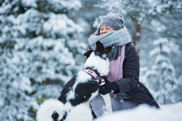 istock Woman playing with dog in snowy forest 1063735896